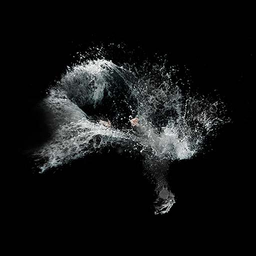 a large splash of water in motion—with only hands visible at the centre after a jump into a pool of water