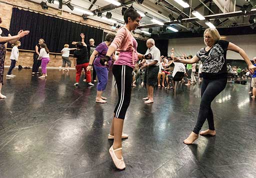 Participants of all ages and genders dance in on of Queensland Ballet's dance rehearsal studios.